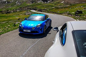 Sports car Renault Alpine coming towards Porsche GT3 on mountain road
