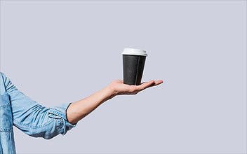 Hand holding a coffee to go on isolated background