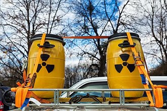 Two yellow metal barrels with signs for radioactivity on roof rack