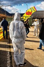 People in protective suits and with gas masks demonstrate against the storage of nuclear waste