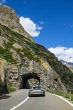 Supercar sports car Porsche GT3 driving tunnel carved in rock