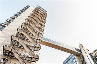 Modern office buildings with spiral staircases and pedestrian bridge between buildings