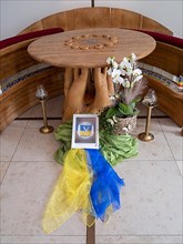 Picture with peace dove and flag of Ukraine on silk cloths in the Ukrainian national colours blue and yellow in the sanctuary of Germany's first private ecumenical motorway church Geiselwind Light on ...