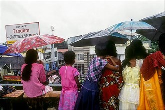 Girls with umbrella admiring Atham festival procession in Tripunithura near Ernakulam