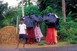 Girls feeling shy to see the camera during a rainy day near Mukkali