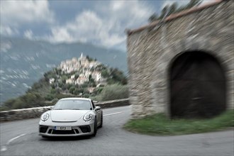 Dynamic photo with speed effect of supercar sports car Porsche GT3 in tight curve of historic track of Rally Monte Carlo 1965