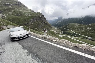 Supercar sports car Porsche 911 GT3 on pass road in Alps to Colle del Nivolet
