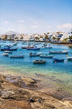 Beautiful seaside downtown of Arrecife with many boats floating on blue water