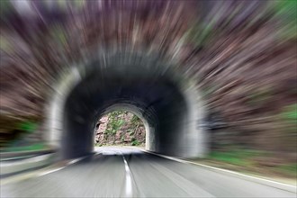 View through windscreen of car driving into narrow tunnel at excessive speed