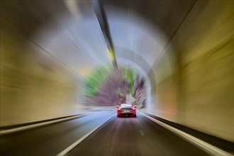 Speeding motorist in sports car speeds through tunnel