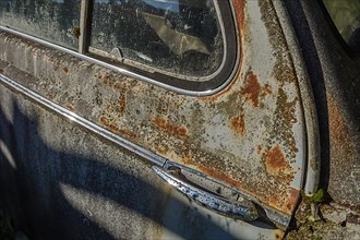 Old car rolled for scrapping in a meadow. Alsace