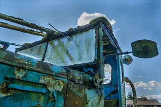 Old car rolled for scrapping in a meadow. Alsace