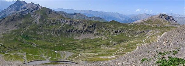 View from Cime de la Bonette on high alpine mountain landscape with road to Col de la Bonette in the background on the right