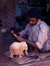 A craftsman with his sandalwood elephant in Mysuru or Mysore