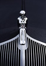 A naked woman as a radiator mascot on a vintage car