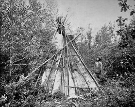 Crow or Absaroka Indian Chief standing in front of the tent of his woman's funeral court