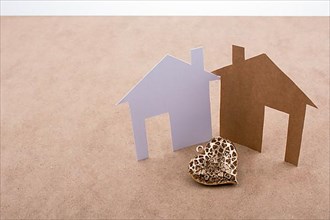 Heart shaped icon and paper houses on a brown background