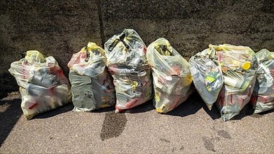 Yellow rubbish bags with plastic waste
