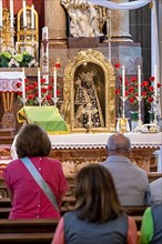Worshippers sit in front of the Black Madonna in the collegiate parish church of St. Philip and St. James in the pilgrimage town of Altoetting. The image of grace is normally in the Holy Chapel