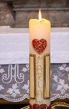 Candle with red heart and the inscription Maria in the collegiate parish church of St. Philipp and Jakob