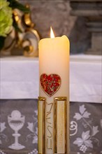 Candle with red heart and inscription Jesus in the collegiate parish church of St. Philip and St. James
