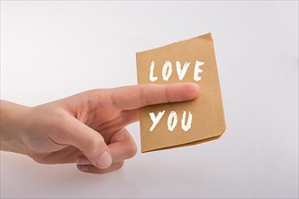 Love You text on paper in hand over white background