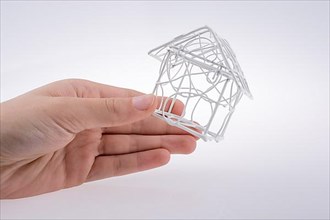Little model house made of white metal wire in hand