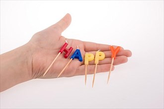 Color candles on sticks write the word happy