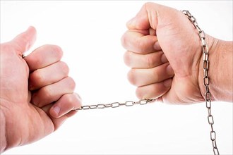Man stretching a thin chain in his hand with a force on white background