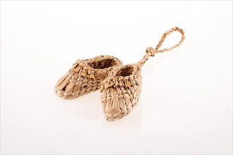 Pair of footware made of straw on white background