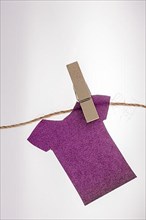 Paper clothes hang on a rope with the help of clothespins