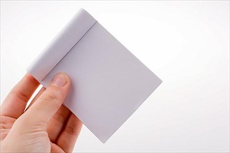 White little notebook in hand on a white background