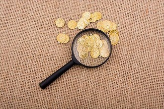 Plenty of fake gold coins behind magnifying glass