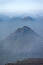 View of mountain peaks between fog