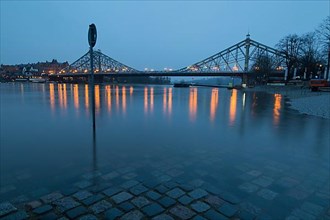 High water in winter on the Elbe at the illuminated Blue Wonder