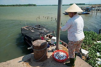 Small fishing pier on the Thu Bon River where a fishing boat is unloaded