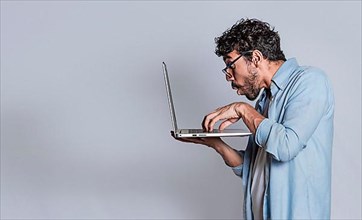 Amazed handsome man with laptop isolated. Surprised person looking at an offer on laptop, surprised people looking at a promotion on laptop isolated