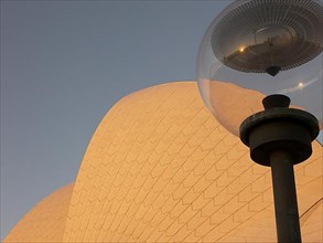 A lamp in front of the Sydney Opera House reflects the city skyline, Australia -