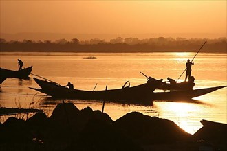 Pole barges on the Niger in the glow of the last sun at a jetty near Bamako, Mali