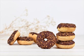 Chocolate glazed donuts with nut sprinkles,