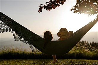 Couple lying in a hammock at sunset, Carinthia