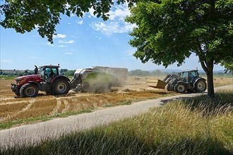 Grain harvest with tractors, baling and loading of hay bales
