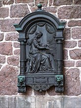 Relief of an organ-playing woman behind the monument to Johann Sebastian Bach,