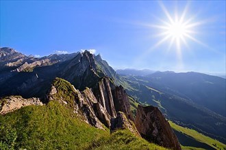 View of the Alpstein mountains in Appenzell, direct backlight with sun star in a cloudless sky