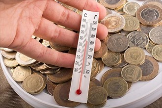 Thermometer in hand beside the Turkish Lira coins,