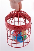 Small globe trapped in a red birdcage,