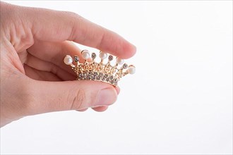 Golden color crown model with pearls on white background,