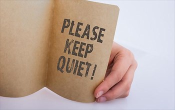 Hand holding a Keep Quiet note as Business concept,