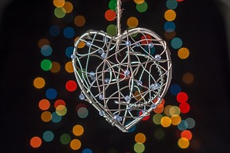 Heart shaped metal cage on a bokeh light background,