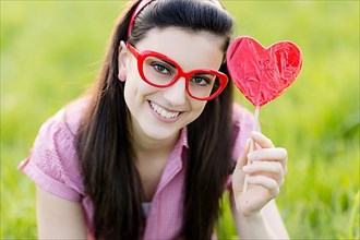 Woman with glasses and heart lolly,
